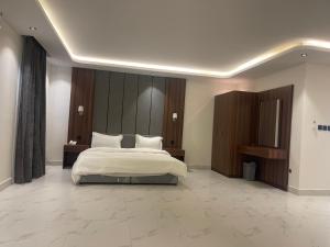 ein Schlafzimmer mit einem großen weißen Bett und einem großen in der Unterkunft شقق درر رامه للشقق المخدومة 10 in Riad