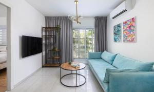 a living room with a blue couch and a table at Central and beautiful - MORE apartments in Beer Sheva