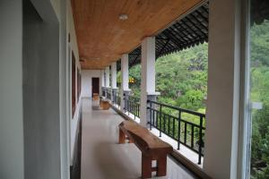 a hallway of a house with benches and a balcony at Ha Giang Historic House & tour in Ha Giang