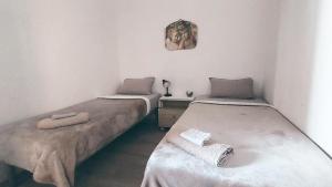 Habitación con 2 camas individuales y escritorio. en La maison d'Eden en Ginosa Marina