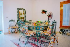 a dining room table with chairs and a mirror at 4 bedrooms villa with private pool in Tunis village faiuym in Qaryat at Ta‘mīr as Siyāḩīyah