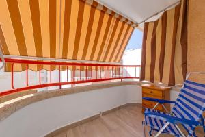 Zimmer mit einem Balkon mit einem Stuhl und einem Tisch in der Unterkunft Cosy Studio Playa del Cura in Torrevieja