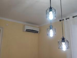 drie lichten aan het plafond in een kamer bij Casetta Fardella 95 in Trapani