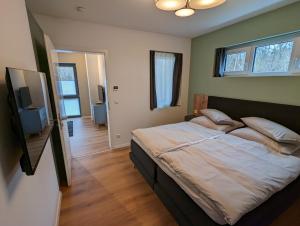 um quarto com uma cama grande e uma televisão em apartments-like-home-199 Mahlow em Mahlow