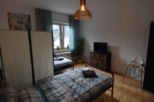 um quarto com uma cama, uma cadeira e uma janela em Ferienwohnung Hohenlimburg em Hagen