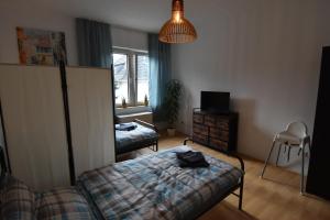 a bedroom with a bed and a chair and a window at Ferienwohnung Hohenlimburg in Hagen