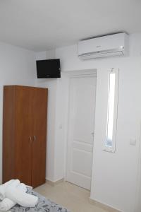 Habitación con cama y TV en la pared. en Imperial Mérida en Merida