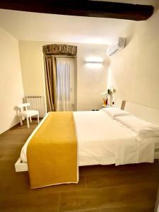 a bedroom with a large bed with a yellow blanket at Opera in Sarzana