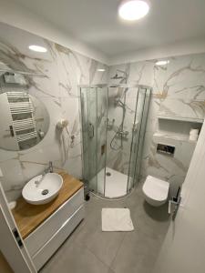 uma casa de banho com um chuveiro, um lavatório e um WC. em Hotel Milena em Milówka