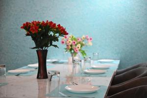 a long table with red flowers in a vase on it at HOTEL DIAMANT INN in Patna