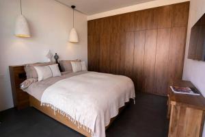 ein Schlafzimmer mit einem großen Bett und einer Holzwand in der Unterkunft Villa 4 chambres - Piscine in Marrakesch