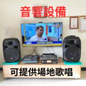 a television on a desk with two speakers and a keyboard at 海豐民宿 Haifeng Bed and Breakfast in Jincheng