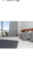 1 dormitorio con 1 cama blanca y ventana en Faustina's suite en Portimão