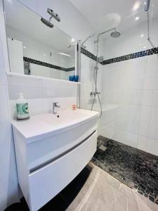 a white bathroom with a sink and a shower at Le Pinède - Apt 4 Prs- Parking - Clim - 500m plages in Antibes