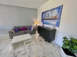 a living room with a couch and a table at Le Pinède - Apt 4 Prs- Parking - Clim - 500m plages in Antibes
