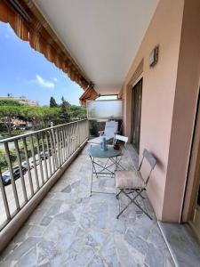 a patio with a table and chairs on a balcony at Le Pinède - Apt 4 Prs- Parking - Clim - 500m plages in Antibes