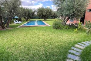 um jardim com uma piscina num quintal em Maison sur terrain privé de 1200m2 avec piscine4x12 em Marrakech