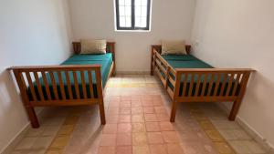 Duas camas num pequeno quarto com uma janela em Maison sur terrain privé de 1200m2 avec piscine4x12 em Marrakech
