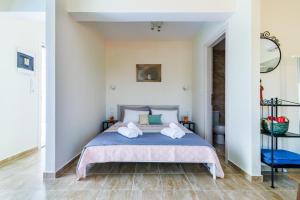 a bedroom with a bed with towels on it at Aloupi Pool Apartment in Skopelos Town