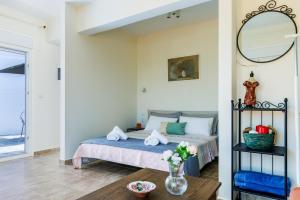 a bedroom with a bed with a mirror and a table at Aloupi Pool Apartment in Skopelos Town +20 photos