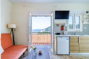 a kitchen with a couch and a table in a room at Aloupi Pool Apartment in Skopelos Town