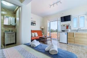 a bedroom with a king sized bed and a kitchen at Aloupi Pool Apartment in Skopelos Town