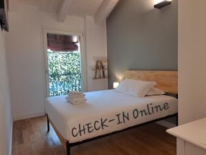 a bedroom with a bed with a check in online sign on it at Cosmopolitan Central Rooms in Bologna