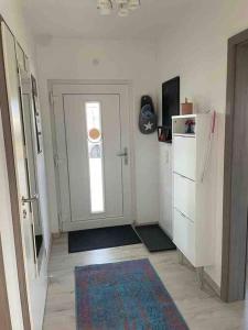 a kitchen with a refrigerator and a door with a rug at Work & Stay Erlensee mit Stellplatz in Erlensee