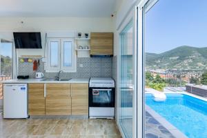 a kitchen with a sink and a swimming pool at Aloupi Pool Apartment in Skopelos Town