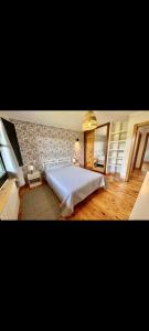 a large bed in a bedroom with a stone wall at El Acebu in Colombres