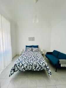 a bedroom with a bed and a blue couch at Casa da Salúquia in Moura