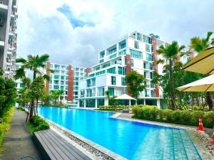 a swimming pool in front of a building at Near Central Festival- 5mims Walk- Infinity Pool & Comfort Room@The One Chiang Mai Condo in Chiang Mai