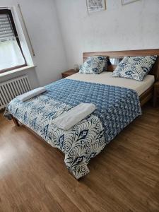 Schlafzimmer mit einem Bett mit einer blauen und weißen Bettdecke in der Unterkunft Gemütliche Gäste Suite für ruhige Nächte. Zentral in Ichenhausen
