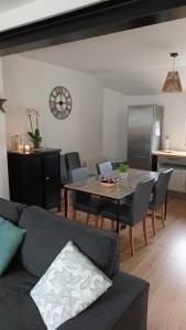 een woonkamer met een bank en een tafel met stoelen bij HoLiDaYs in Arques