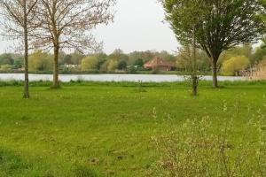 a field of grass with trees and a body of water at HoLiDaYs in Arques