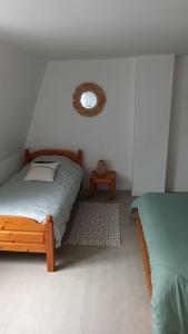 een slaapkamer met 2 bedden en een spiegel aan de muur bij HoLiDaYs in Arques