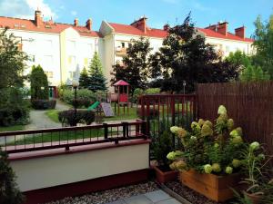a garden with a fence and some plants at Apartament 2 sypialnie, 2 łazienki, taras, parking in Warsaw