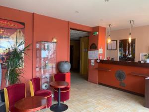 - une salle d'attente avec des murs rouges et des chaises rouges dans l'établissement Hôtel Noz Vad, à Carhaix-Plouguer