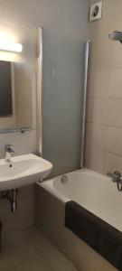 La salle de bains est pourvue d'un lavabo et d'une baignoire à côté d'un miroir. dans l'établissement Appartement Dumortier, à Knokke-Heist