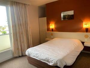 - une chambre avec un lit et une fenêtre dans l'établissement Hôtel Noz Vad, à Carhaix-Plouguer