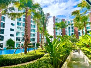 a resort with a swimming pool and palm trees at Near Central Festival- 5mims Walk- Infinity Pool & Comfort Room@The One Chiang Mai Condo in Chiang Mai