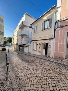 a cobblestone street with buildings on the side at Bluebay Sesimbra - Laura in Sesimbra
