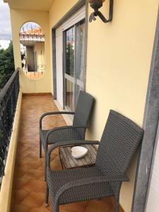 two chairs and a table on a balcony at Faustina's suite in Portimão