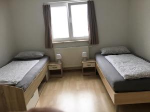 2 camas en una habitación con ventana en Ferienwohnung Heimatliebe, en Waltenhofen