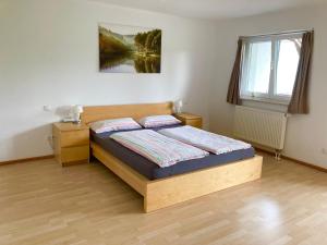 Schlafzimmer mit einem Bett und einem Fenster in der Unterkunft Ferienwohnung Heimatliebe in Waltenhofen