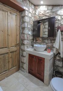 a stone bathroom with a sink and a toilet at Petronas Land House 2 in Archangelos