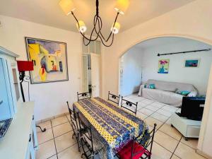 Habitación con mesa y sala de estar. en Maison des Oliviers : Maison 5 Prs, 400m plages, en Antibes