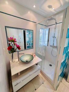 y baño con lavabo de cristal y ducha. en Maison des Oliviers : Maison 5 Prs, 400m plages, en Antibes