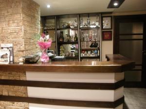 a bar with a vase of flowers on a counter at Guest House Raffe in Dobrinishte +226 photos