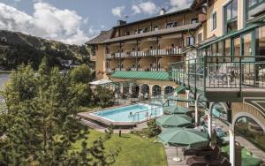 a hotel with a swimming pool next to a building at Seehotel Jägerwirt in Turracher Hohe